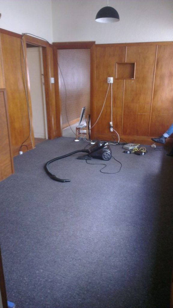 A photo that shows a vacuum cleaner that could easily be moved to make the room look better
