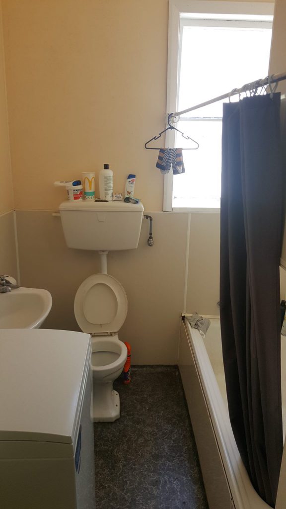 An open toilet seat in a property listing photo