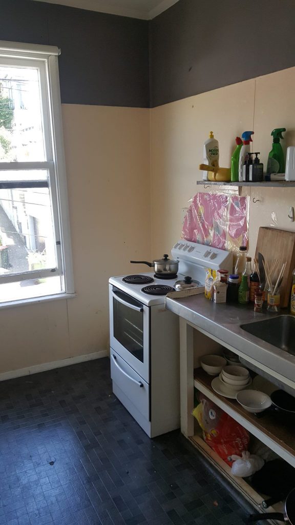 A property listing photo that shows a plastic Sun Rice package being used as an oven splashback